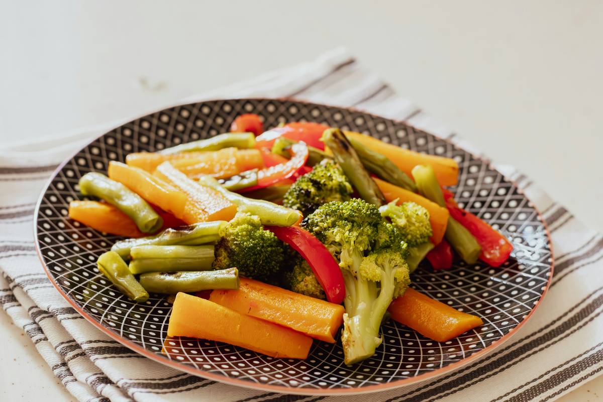 Bar chart comparing fiber content per cup of top high-fiber vegetables: artichokes (10g), peas (9g), broccoli (5g), Brussels sprouts (4g), carrots (3.5g)